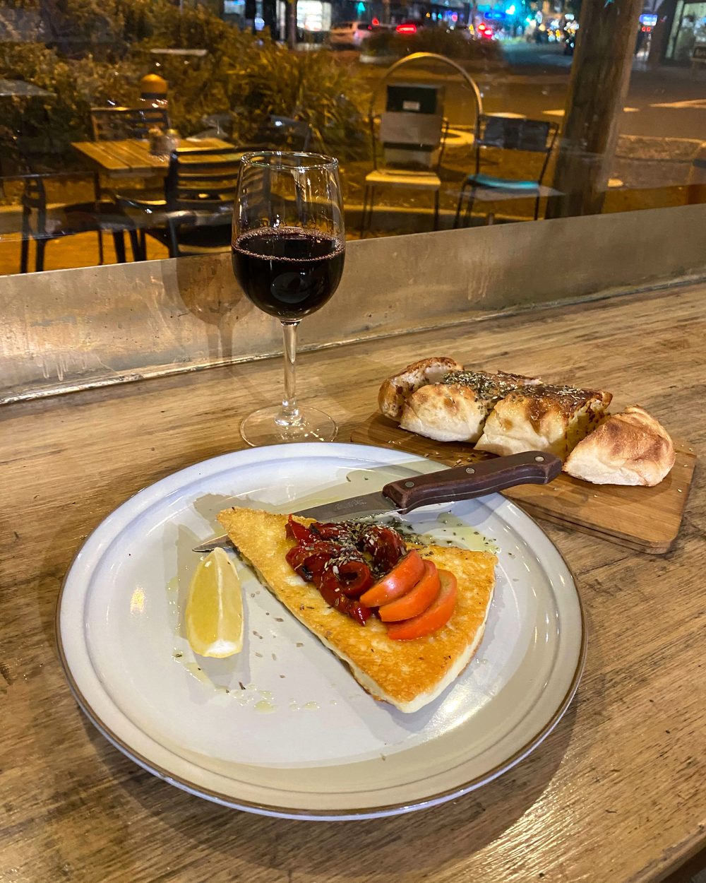Saganaki with garlic bread and red wine by the window at Black Drop, Black Rock